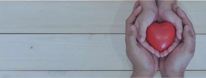 Two hands holding a heart icon.